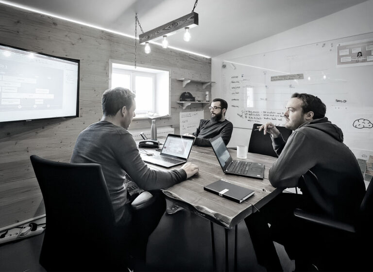 3 Personen mit Laptops im Meeting