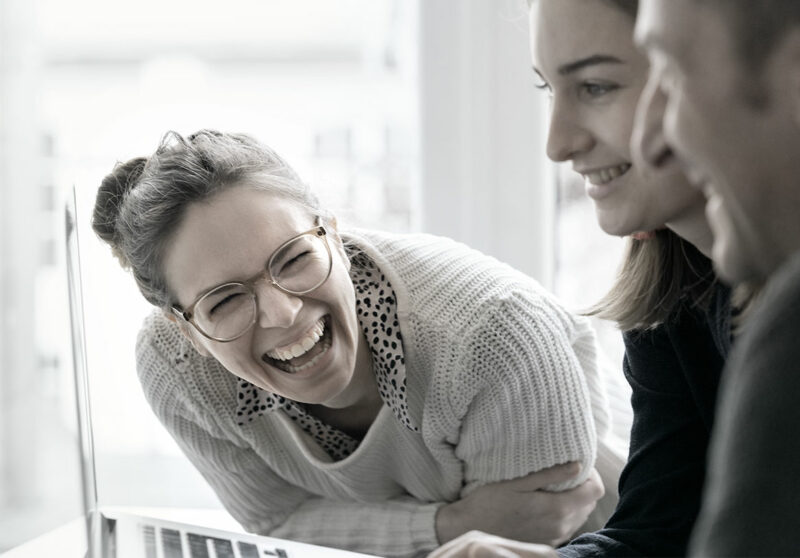 Zwei Frauen und ein Mann am Laptop