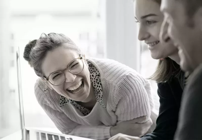 Zwei Frauen und ein Mann am Laptop