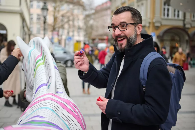 Unser Geschäftsführer, Alex Reinhold, der begeistert einen Stift in der Hand hält, um das Zebra zu bemalen.